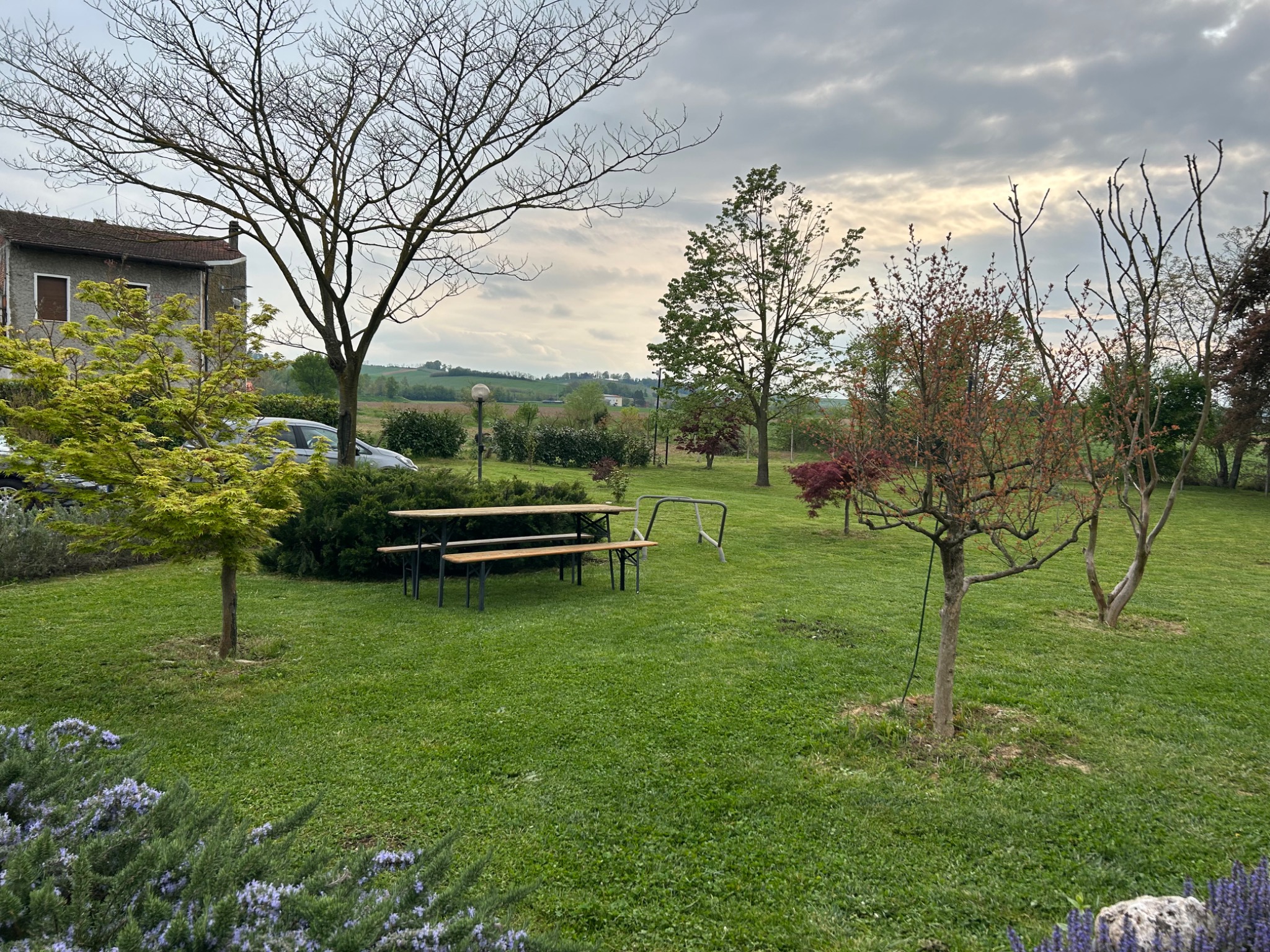A Monferrato garden beneath a changing sky after unsettled weather